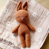 Sleepy crocheted bunny on floral baby blanket